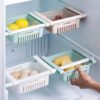 Adjustable Fridge Storage Basket clipped onto a refrigerator shelf containing fresh vegetables