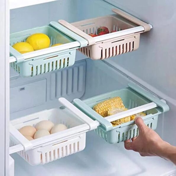 Adjustable Fridge Storage Basket clipped onto a refrigerator shelf containing fresh vegetables