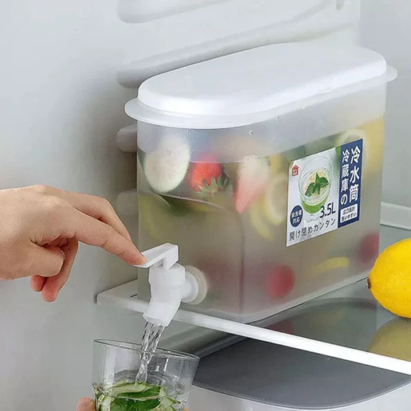 Clear 2.4L plastic cold juice beverage dispenser with a white dispensing tap sitting on a counter.