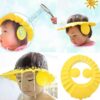 A soft pink baby shower cap with ear protection flaps sitting on a clean surface.