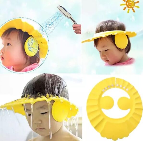 A soft pink baby shower cap with ear protection flaps sitting on a clean surface.