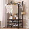 Double pole freestanding coat hat rack with 3 shelves holding clothes and shoes in a bedroom