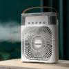 White 4-in-1 portable mist air cooler fan with 600ml water tank capacity and Type-C power cable on a desk
