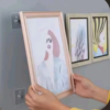 Heavy duty adhesive wall hook holding a photo frame close up